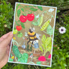 Illustrated print with a bee gardening among plants held in front of greenery