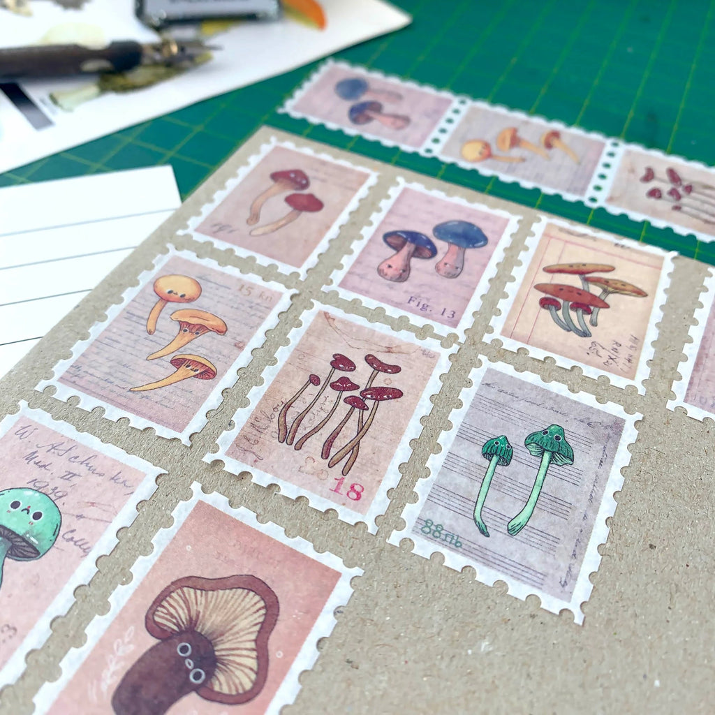 Collection of mushroom-themed stamps on a surface with a bottle of ink and paper in the background.