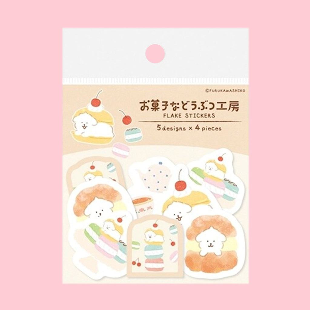A package of cute Japanese sticker sheets featuring pastel macarons, cakes, and a small character on a cream card, set against a solid pink background.