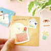 Set of cute stickers on a pink surface with a hand holding a card featuring a sticker.