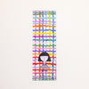 A tall, narrow bookmark with a colourful abstract grid pattern and a simple illustration of a girl near the bottom. The text reads 'shuh. printed in australia shuhlee.com'
