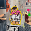A die-cut vinyl sticker of a cartoon artist drawing in a notebook, applied to a clear tumbler. The sticker features a character with black cap, a pink shirt with a yellow star, and tan legs, surrounded by a bright yellow border.
