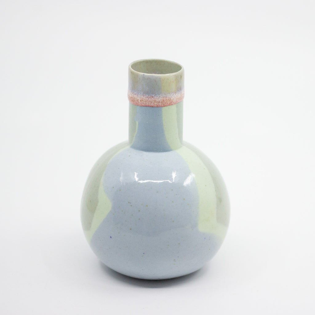 Round ceramic vase with gradient color design on a white background