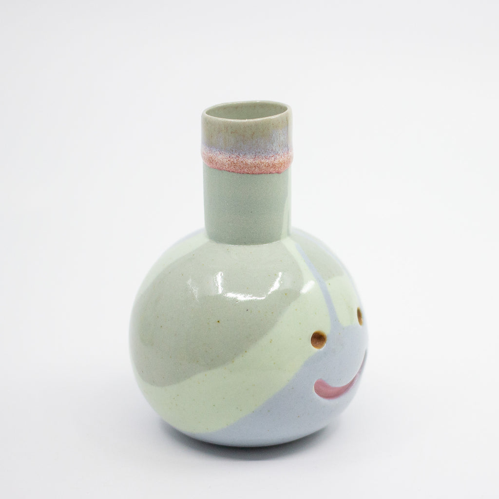 Decorative vase with a smiley face design on a white background