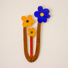 Wooden letter 'U' with colourful flower attachments on a beige background