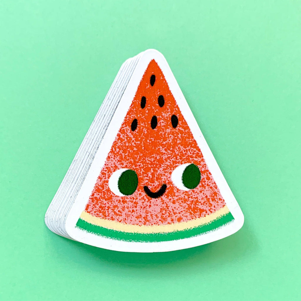 Magnet of a smiling watermelon slice on a green background