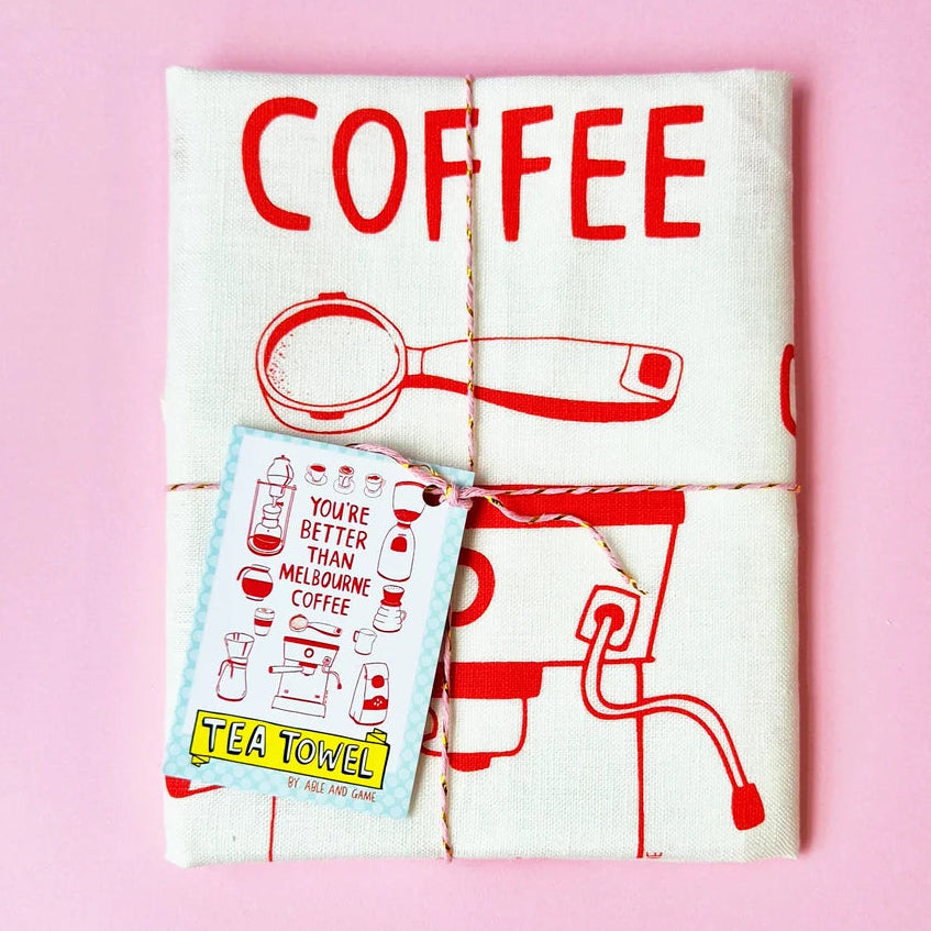 Tea towel with coffee-themed design on a pink background