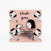 Packaging card with pin. Card is pink, with illustrated dogs. The pin features a girl holding a dog. Girl has pink cheeks. 