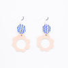 Two drop earrings with sterling silver hooks. Each earring has two ceramic pendants, the first is circular with wavy blue handpainted lines. The second is a larger circular pendant with pink colour and flower shape. On white background. 