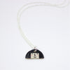 Sterling silver necklace featuring a hand-painted ceramic pendant with a fun, expressive face and large hair design, displayed on a white background.