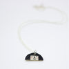 Sterling silver necklace featuring a hand-painted ceramic pendant with a fun, expressive face and large hair design, displayed on a white background.