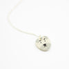 Sterling silver necklace featuring a round ceramic pendant hand-painted with a light grey and cream dog face, including expressive eyebrows and a small brown mouth, displayed on a white background.