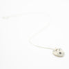 Sterling silver necklace featuring a round ceramic pendant hand-painted with a light grey and cream dog face, including expressive eyebrows and a small brown mouth, displayed on a white background.