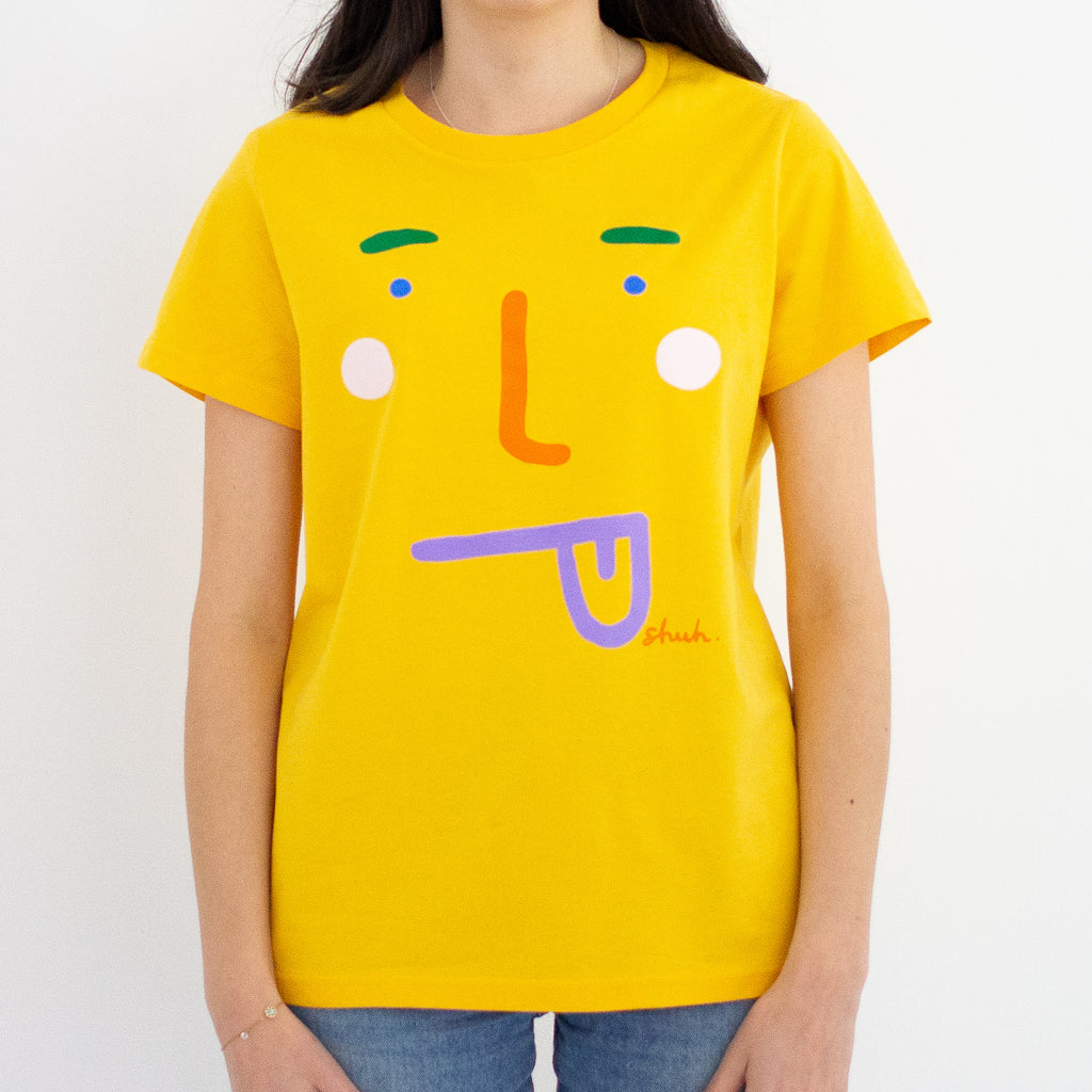 A model wearing the boo tee. Blue coloured tee, with a stylised face with tongue poking out. 
