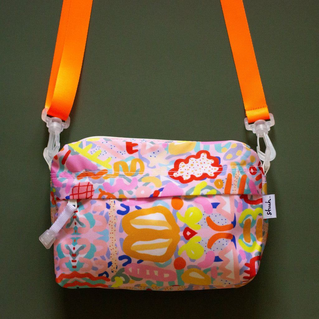 Front view of the Coral everyday bag. With alternate orange strap. Bright multicoloured impressionistic undersea patterns. 