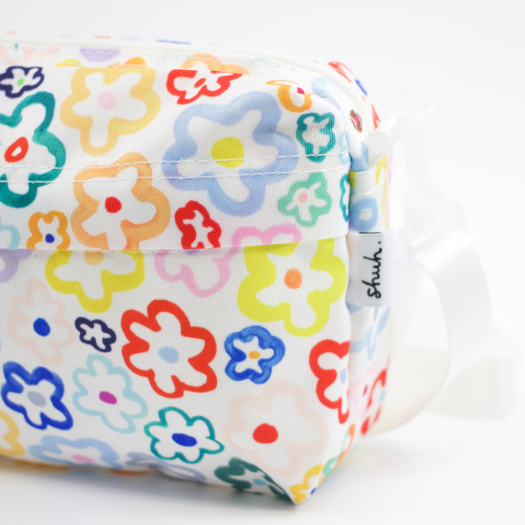 Tag view of the Daisy everyday bag. Multicoloured daisy illustrations on a white background. 