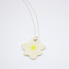 Sterling silver necklace featuring a large, hand-painted ceramic daisy-shaped pendant with black detailing on a white background.