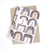 Front view of the Fab Faces card print. Different faces on a pink background. 