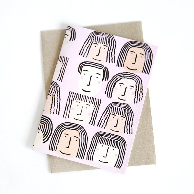 Front view of the Fab Faces card print. Different faces on a pink background. 