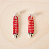 Pair of handmade ceramic earrings shaped like fish with a red check pattern and small white faces, finished with silver stud backings. Designed by shuh.