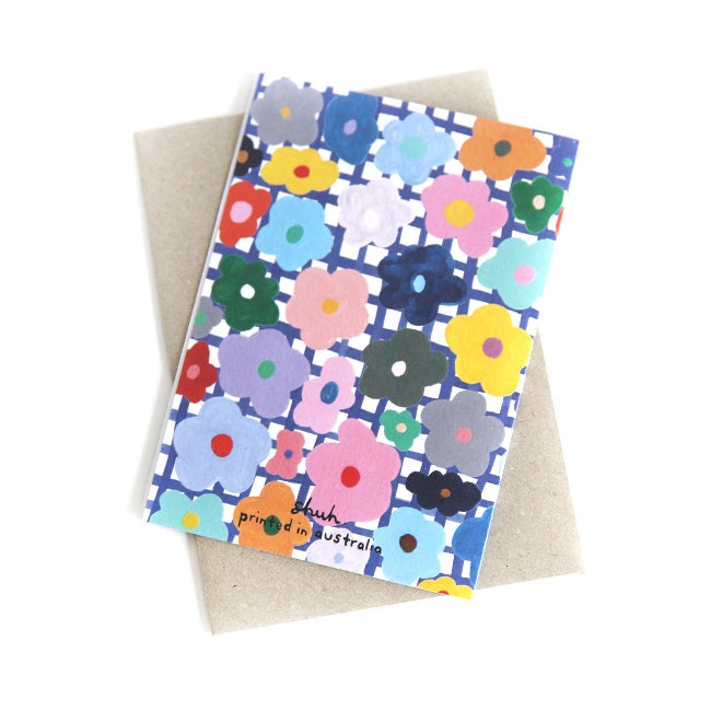 Back view of the flower print card. Multicoloured flowers on a white and blue chequered background.