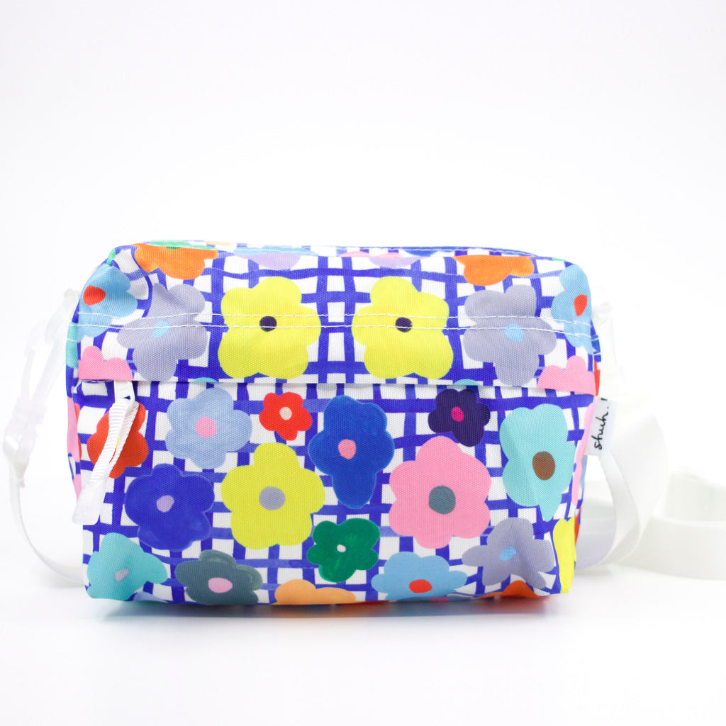Front view of the flower everyday bag. Bright flower illustrations over a blue and white checkered background.
