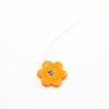 Sterling silver necklace featuring a bright orange ceramic flower-shaped pendant with a black dotted centre, displayed on a white background.