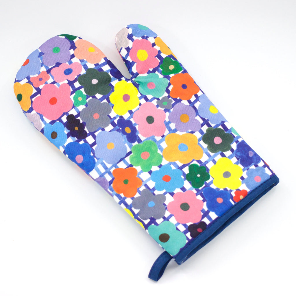 Top view of the flower oven mitt. Multicoloured flowers over the top of a blue and white checked background.