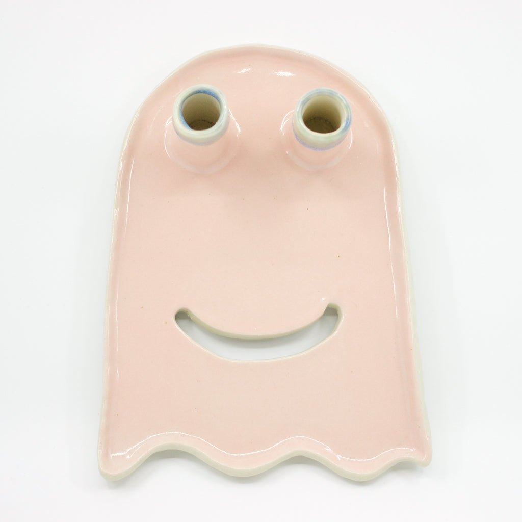 Top view of the ghost trinket dish. Two spouts act as eyes and can hold flowers. Dish is ghost shaped. Pink colour, and a cutout smile. 