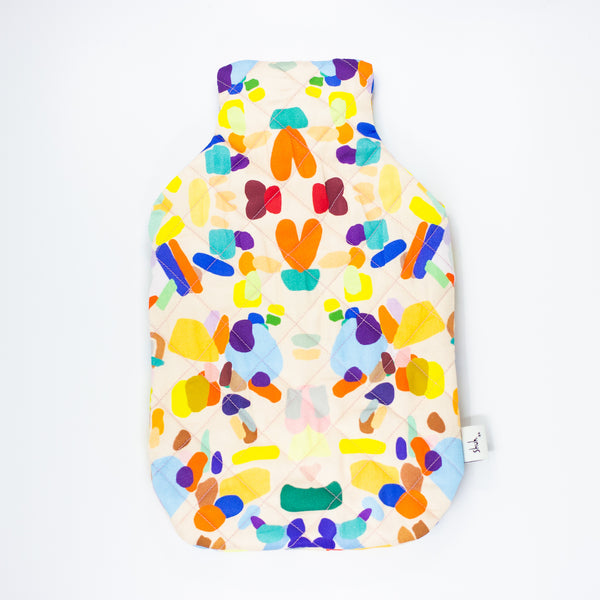 Front view of the hanging out hot water bottle cover.  Multi coloured shapes and patterns on a peach background.