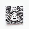 Enamel pin featuring a hand-drawn happy monster character with a big smile and bold black outline, on a card with squiggle designs and 'shuh. pins' labelling. 