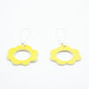 Flat view of two ceramic drop earrings, with sterling silver hooks. Ceramic pendants are circular flower shaped with a hollow centre. Hand painted yellow. 