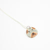 Sterling silver necklace featuring a round ceramic pendant hand-painted with a dog’s face in beige and brown tones, displayed on a white background.