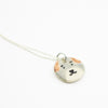 Sterling silver necklace featuring a round ceramic pendant hand-painted with a light grey and beige dog face, including brown ears and a small black nose and mouth, displayed on a white background.