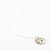 Sterling silver necklace featuring a round ceramic pendant hand-painted with a light grey and beige dog face, including brown ears and a small black nose and mouth, displayed on a white background.