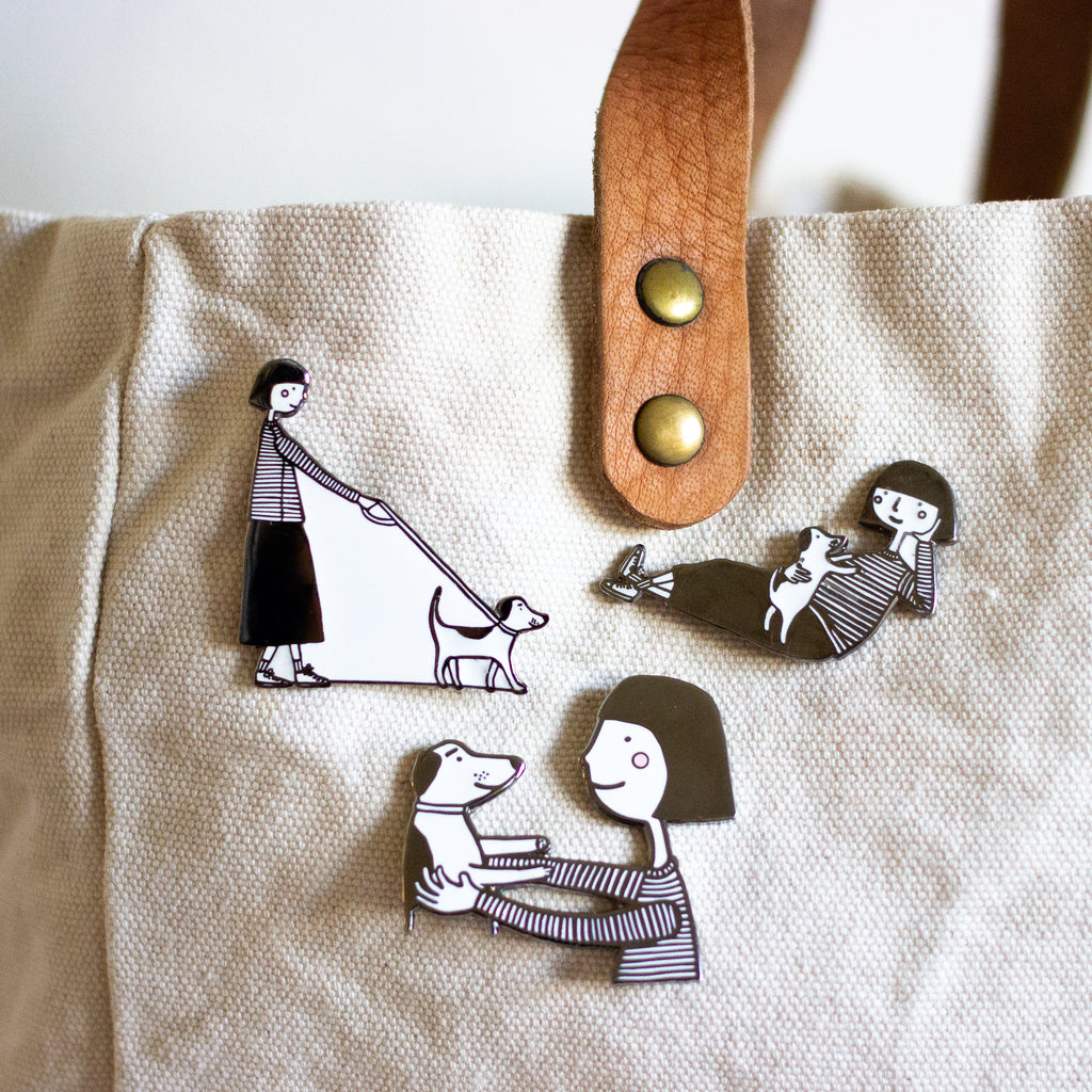 closeup of the 3 dog pins from the shuh pin collection. Attached to a bag. 