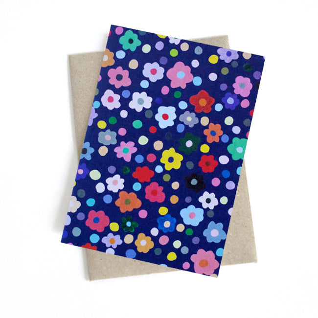Front view of the Salad card. Multicoloured flower heads and polka dots on a navy background.