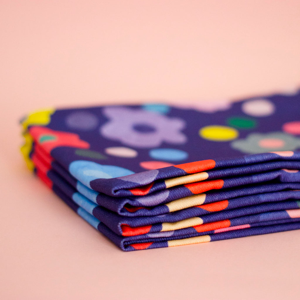 Side view of the Salad napkin set. Bold flower patterns and polka dots, with all shuh.’s favourite colours, on a navy background