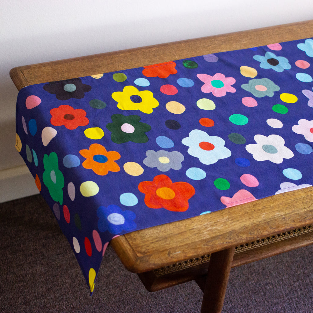 Top view of the Salad table runner. Bold flower patterns and polka dots, with all shuh.’s favourite colours, on a navy background