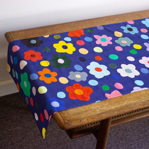 Top view of the Salad table runner. Bold flower patterns and polka dots, with all shuh.’s favourite colours, on a navy background
