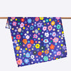 Salad tea towel, front view. Flowers and polkadots, all multicoloured, on a navy background. 
