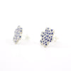 Side view of a pair of handmade ceramic stud earrings shaped like small clouds with an indigo blue dotted pattern on white. Sterling silver studs.  Designed by shuh.