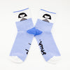 Front view of the shuh. girl socks. Featuring the iconic shuh. girl and a blue and white striped pattern, these socks are designed to bring fun and imagination to your feet