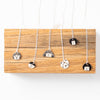 Collection of shuh. sterling silver necklaces, with handmade ceramic pendants and sterling silver chains, arranged on a wooden board. 