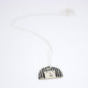 Sterling silver necklace featuring a hand-painted ceramic pendant with a playful straight-haired face design, displayed on a white background.