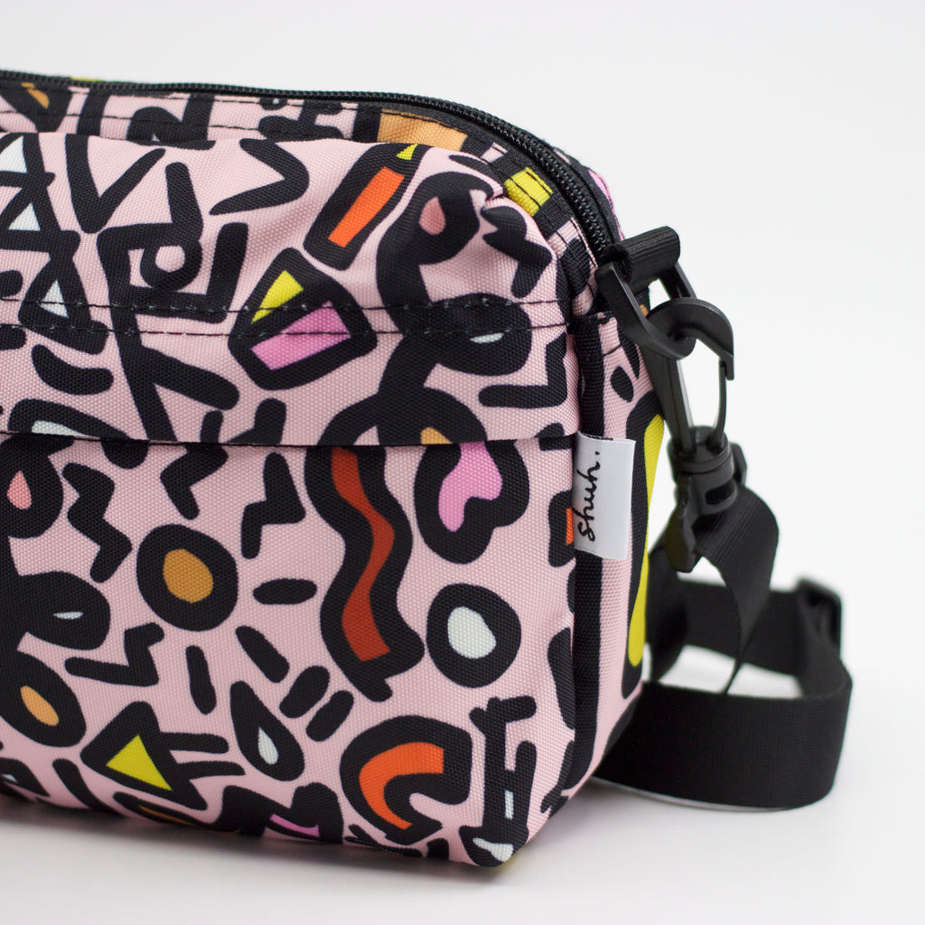 Side view of the sweet everyday bag.  Pink background with black designs. 