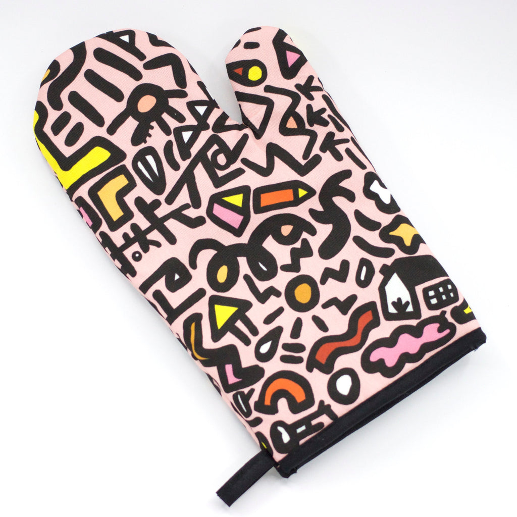 Top view of the sweet oven mitt. Street inspired design, pink, black, and yellow designs on a pink background. 