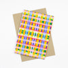 Front view of the Tartan print card. Multicoloured checkered print, orange, purple, green, yellow, blue, lavender, and pink. 