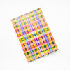 Front view of the Tartan notebook, with multicoloured tartan print. Purple, blue, green, yellow, and orange. 