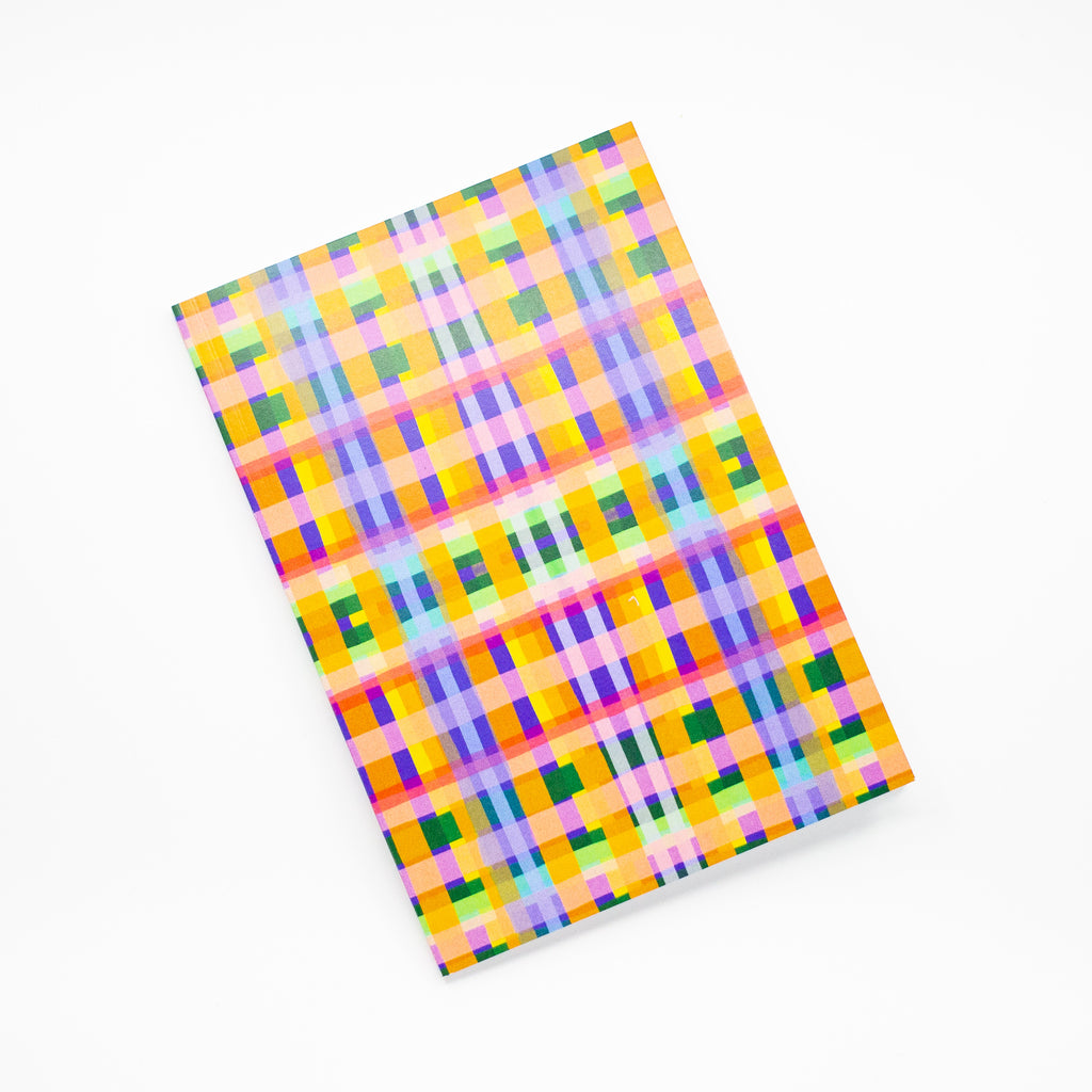 Front view of the Tartan notebook, with multicoloured tartan print. Purple, blue, green, yellow, and orange. 
